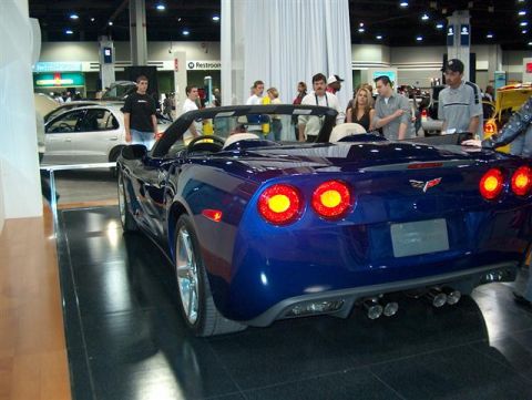 2001 Ford Crown Victoria - A blue convertible sports car is shown from the rear at an auto show.