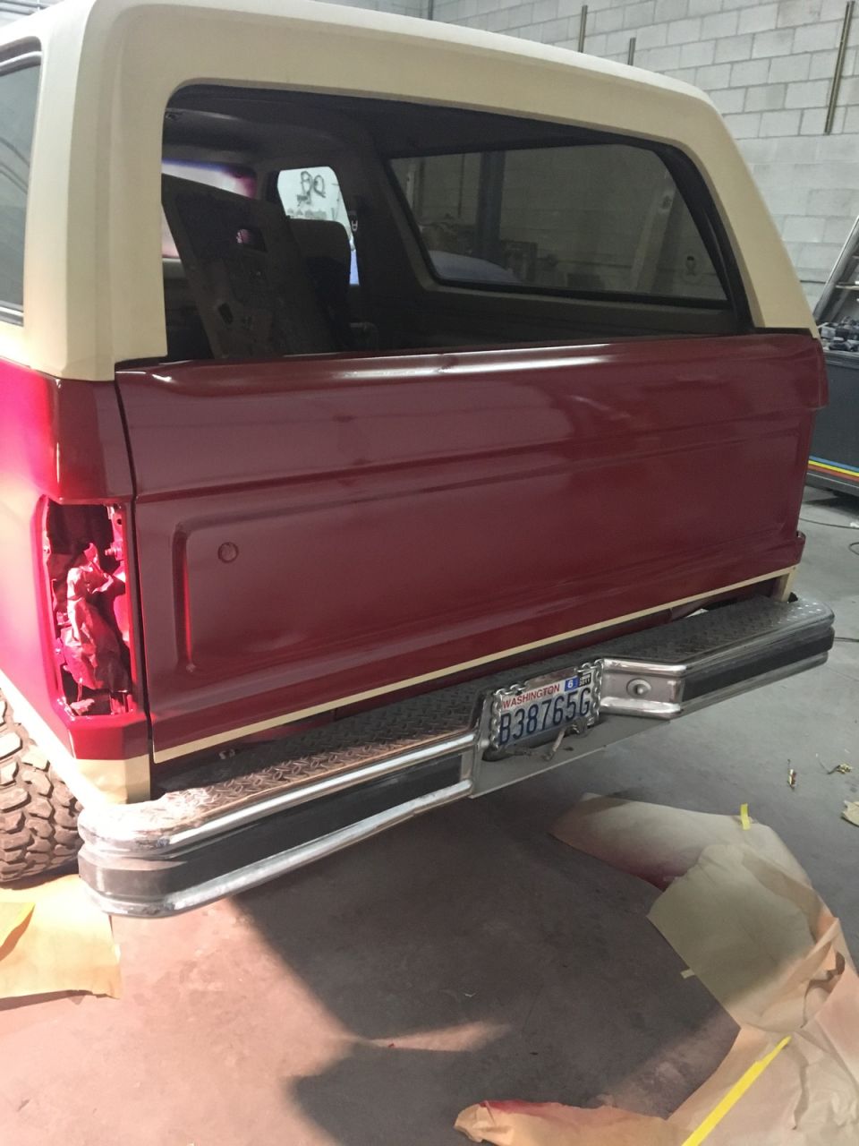 Rear passenger side of a red and tan Ford Bronco with a Washington license plate.