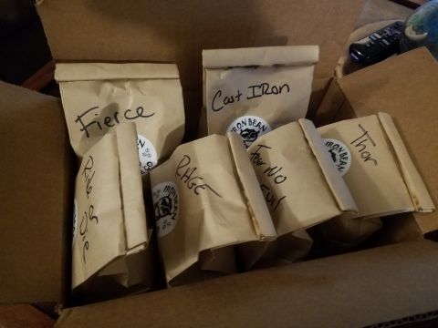 2018 Ford Bronco - A cardboard box filled with several small brown paper bags, each labeled with handwritten text and a circular sticker. The bags appear to c…