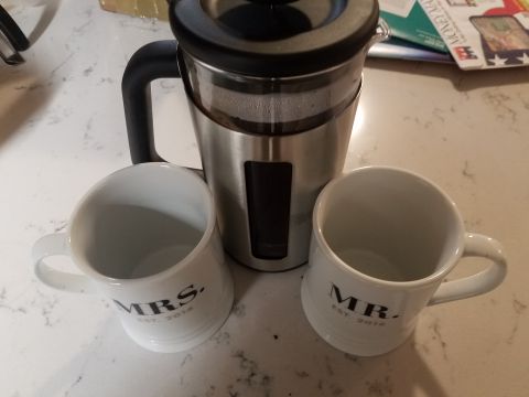 2018 Ford Bronco - A stainless steel French press coffee maker sits on a countertop next to two white ceramic mugs, one labeled "MRS. EST. 2016" and the other…