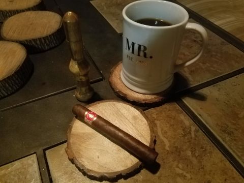 2018 Ford Bronco - A cigar rests on a wooden coaster next to a mug that says "MR. EST. 2016" and a wooden cigar holder. The items are placed on a tiled surfac…