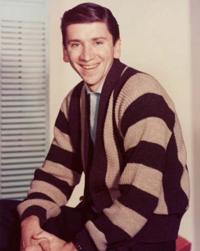 1967 Ford Custom Wagon - A man is smiling and looking at the camera. He is wearing a striped cardigan over a blue shirt.
