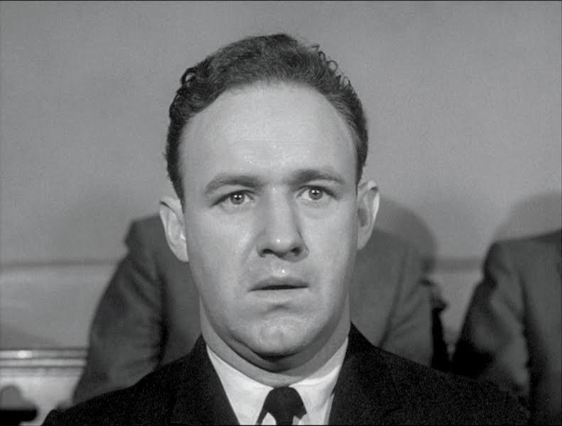 Close-up of a man's face in a suit and tie.