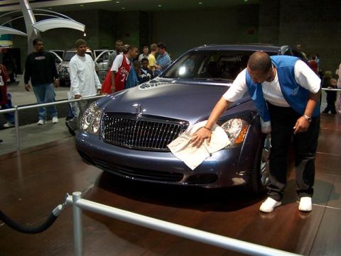 2001 Ford Crown Victoria - Detailer polishes a luxury sedan on display at an auto show event.