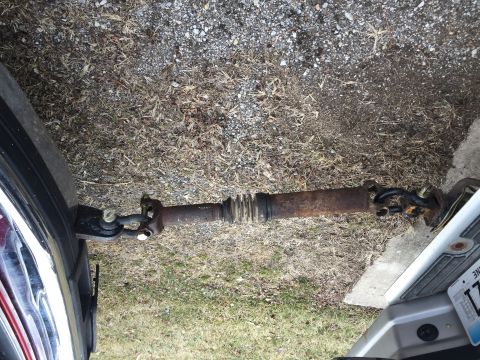1967 Ford Custom Wagon - Driveshaft and U-joints removed from a vehicle, showing signs of rust and wear.