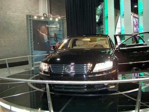 2001 Ford Crown Victoria - A black Volkswagen sedan is displayed with its doors open at an auto show.