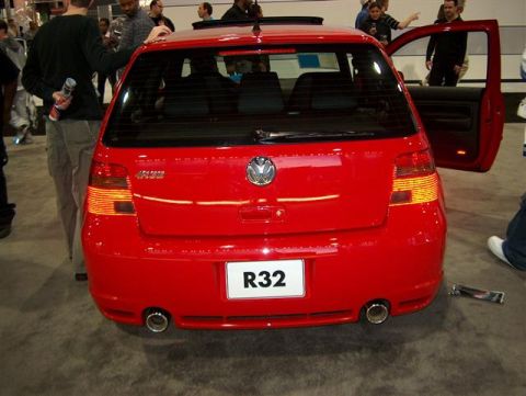 2001 Ford Crown Victoria - Rear view of a red Volkswagen Golf R32 at an auto show, showing its distinctive badging and exhaust.