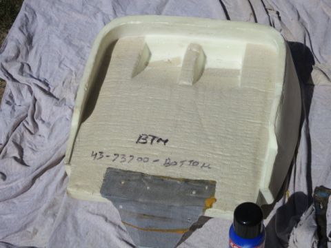 1991 Ford Bronco - A foam part, possibly from a vehicle interior, is shown with handwritten identification and a metal bracket attached.