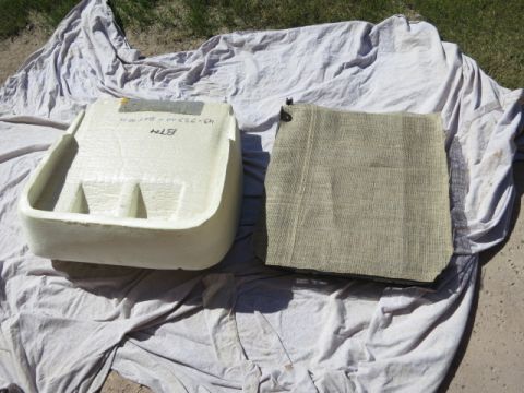 1991 Ford Bronco - A foam part, possibly a seat base, and a piece of fabric are laid out on a tarp.