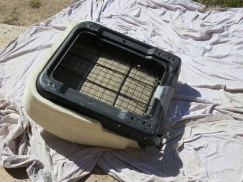 1991 Ford Bronco - Frame of a car seat, showing the internal spring mechanism, laid out on a drop cloth.