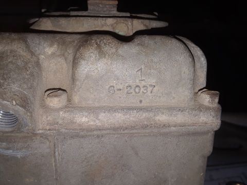 1994 Ford Bronco - A close-up view of a metal component, possibly from an engine, showing stamped identification numbers '1' and '6-2037'.