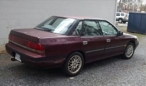 1994 Subaru Legacy - Maroon 1994 Subaru Legacy sedan seen from the rear three-quarter angle.
