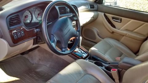 1994 Subaru Legacy - The interior of a 1995 Subaru Legacy Outback features tan leather seats and wood trim accents.