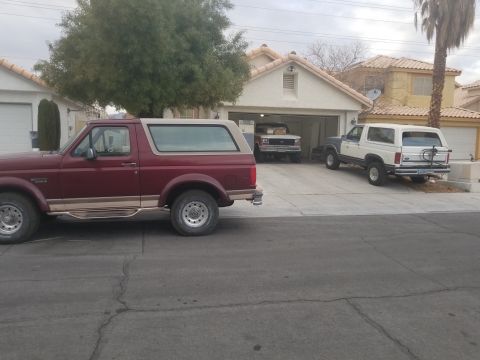 1967 Ford Bronco - Three Ford Broncos are parked in a residential driveway.