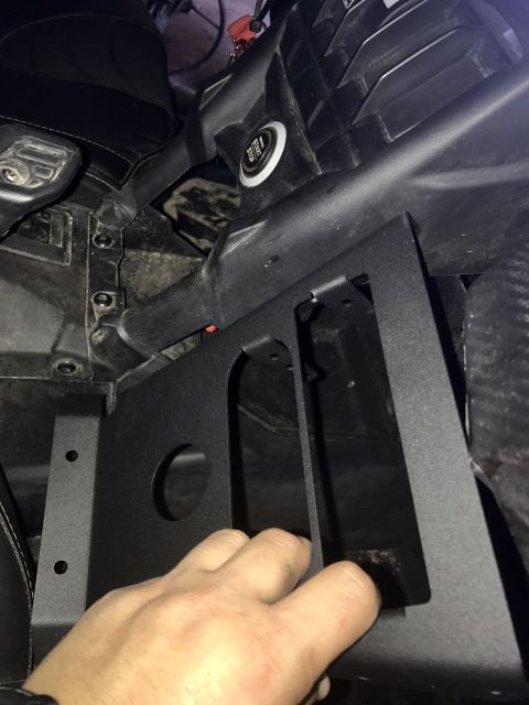 1988 Ford Bronco - A hand is shown installing a custom bracket into the dashboard of a vehicle, near the ignition.