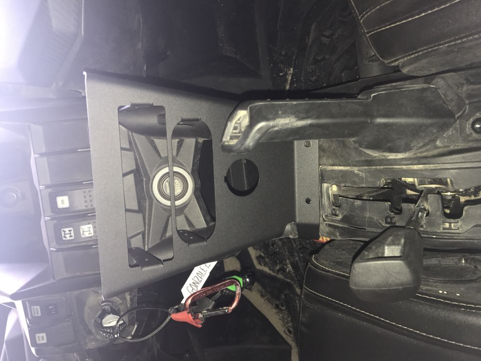 Interior view of a vehicle part with a fan, carabiner, and some electronic components