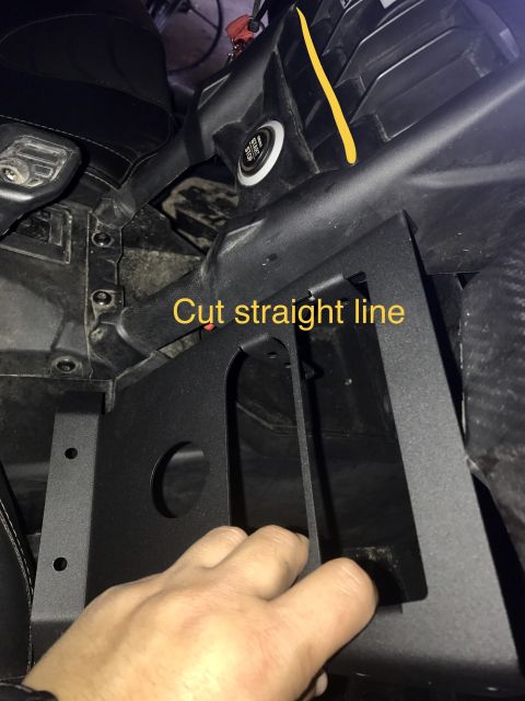 1988 Ford Bronco - A hand installs a black metal bracket inside a vehicle's interior, with instructions to 'Cut straight line' visible.