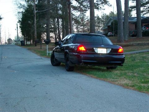 2001 Ford Crown Victoria - Rear view of a black 2001 Ford Crown Victoria parked on a residential street.