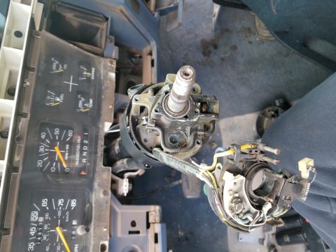 1967 Ford Bronco - Close-up view of a vehicle's disassembled steering column and instrument cluster, showing wiring and mechanical components.