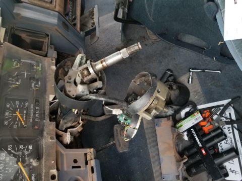 1967 Ford Bronco - Interior view of a disassembled steering column and dashboard components, with tools and parts scattered around.