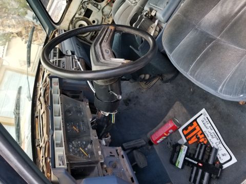 1967 Ford Bronco - The interior of a vehicle is shown with the dashboard disassembled, revealing the steering column and instrument cluster.