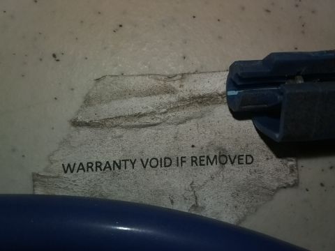 1993 Ford Bronco - A sticker indicating that the warranty is void if removed is partially visible on a textured surface.