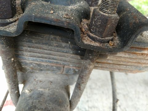 1992 Ford Bronco - Close-up view of a vehicle's leaf spring and U-bolt assembly, showing signs of wear and dirt accumulation.
