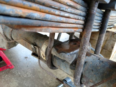 1992 Ford Bronco - Rusty leaf springs and axle assembly, likely undergoing maintenance or repair.