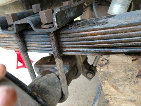 1992 Ford Bronco - This photo shows the leaf spring and U-bolts securing the axle, with a red jack stand visible in the background.