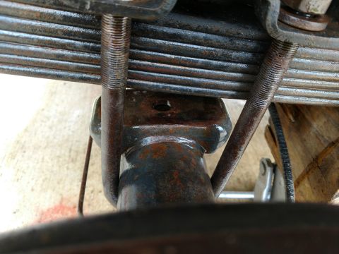 1992 Ford Bronco - This photo shows a close-up view of a vehicle's rear axle and leaf spring assembly, highlighting rusted components.
