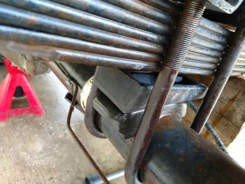 1992 Ford Bronco - Close-up view of leaf springs and axle assembly, showing U-bolts and a wedge block.