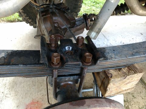 1992 Ford Bronco - Close-up of U-bolt hardware on a vehicle's leaf spring suspension system.