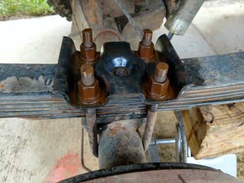 1992 Ford Bronco - This image shows the U-bolt hardware securing a leaf spring to a vehicle's axle.