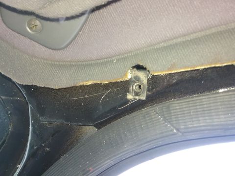 1993 Ford Bronco - Close-up of an interior trim clip on the roof lining, showing wear and dust.