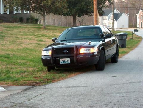 2001 Ford Crown Victoria - This 2001 Ford Crown Victoria police car is seen from the front, equipped with a push bar and a license plate reading ADAM-12.