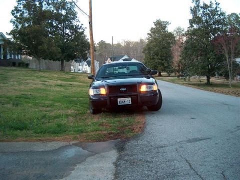2001 Ford Crown Victoria - This 2001 Ford Crown Victoria, identified by its distinctive body style and push bar, is seen from the front on a residential street.