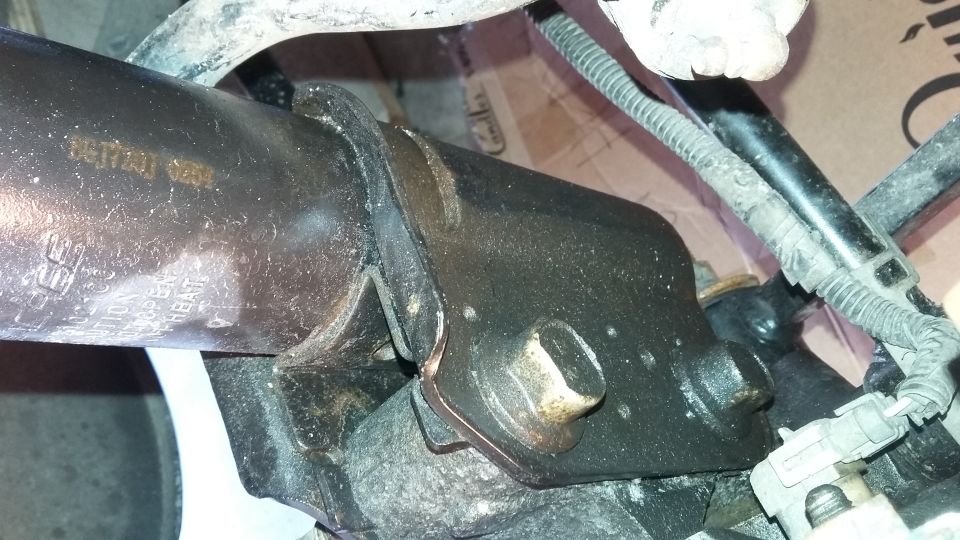 Close-up of a greasy suspension part with some stamped numbers