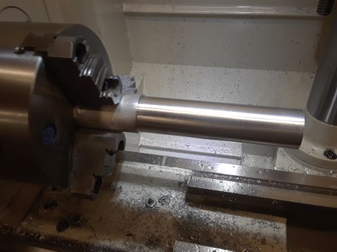 1994 Ford Bronco - A metal shaft is being worked on by a lathe, with metal shavings visible on the machine bed.