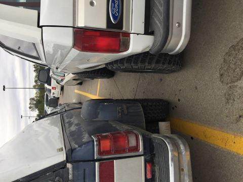 1967 Ford Custom Wagon - Rear view of a white Ford pickup truck, parked next to another vehicle.