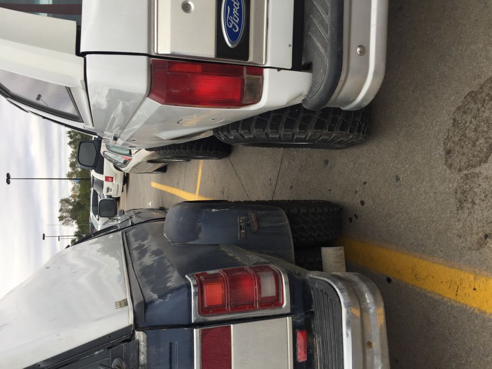 White Ford pickup truck rear view, showing taillight, bumper, and Ford badge