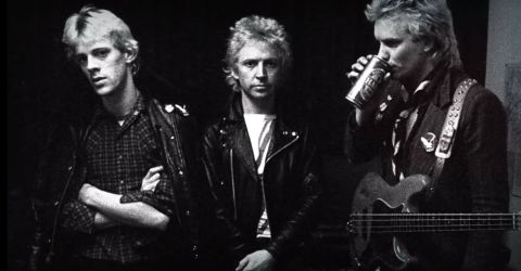 1967 Ford Custom Wagon - A black and white photo shows three men in leather jackets. One man on the right drinks from a can while holding a guitar.