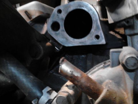 1995 Ford Bronco - Close-up view of an engine's exhaust manifold flange and associated piping.