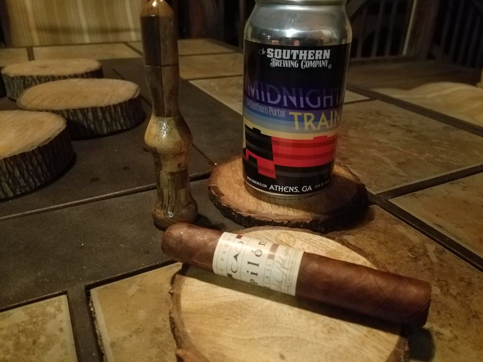 cigar and can of "Midnight Train" Southern Porter beer on wood slices