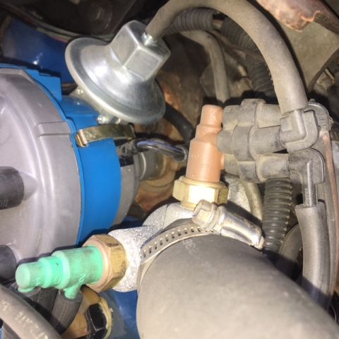 1979 Ford Ranchero - Close-up view of various engine components, including a distributor and sensors, with visible hoses and wiring.