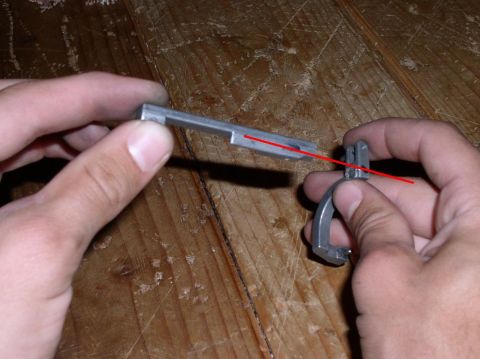 1990 Ford Bronco - Close-up of a metal component with a red line indicating alignment, held by hands.