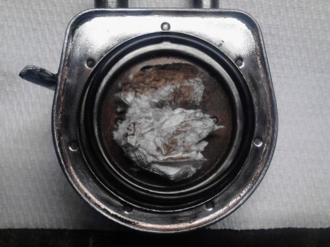 1995 Ford Bronco - This radiator cap shows significant buildup of rust and white debris inside, indicating potential cooling system issues.