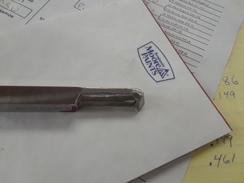 1994 Ford Bronco - A metal tool bit is shown on top of documents, one of which features the Benjamin Moore Paints logo.