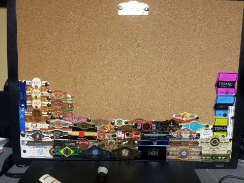 2018 Ford Bronco - A collection of cigar bands is pinned to a corkboard, displaying various brands and designs.