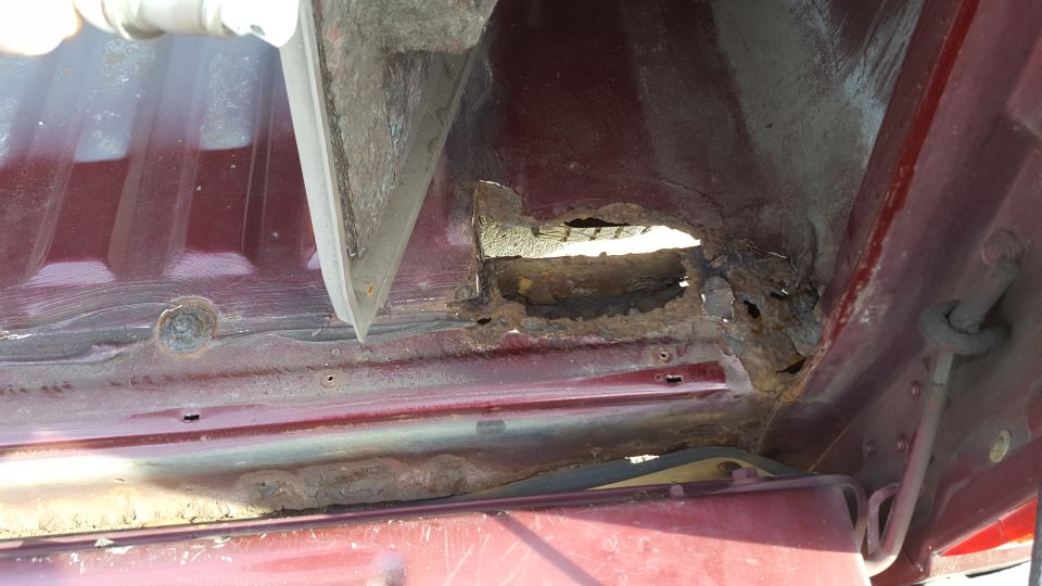 close-up of heavily rusted metal on a vehicle's frame