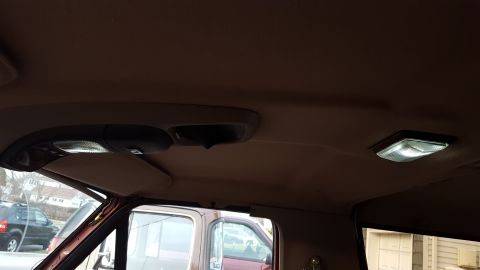 1967 Ford Bronco - Interior view of a vehicle's headliner and dome lights, with another vehicle visible outside.